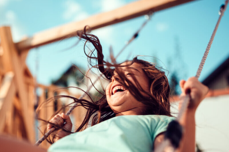 Criança sorridente em um balanço